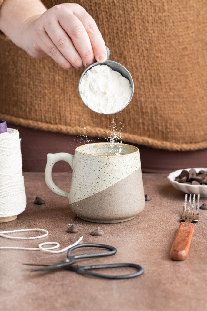 Adding flour to mug to make a microwaveable cake.