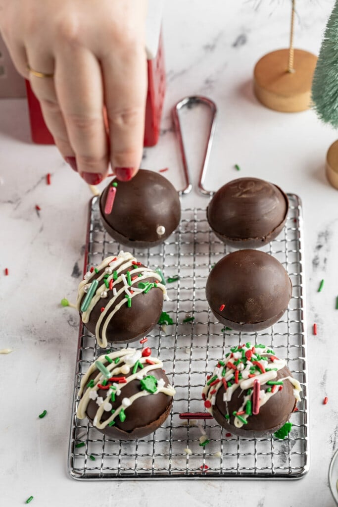 Adding sprinkles to Christmas Hot Cocoa Bombs