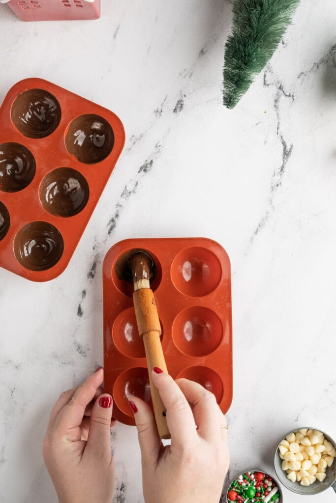 Brushing melted chocolate into spherical molds