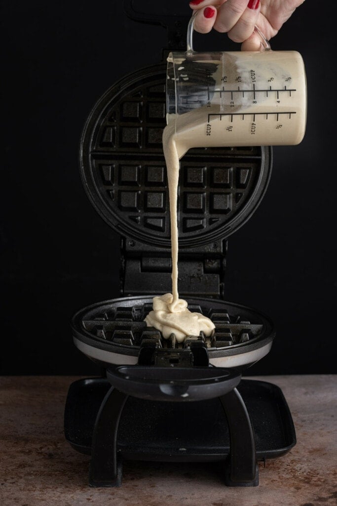 Pouring waffle batter onto waffle iron