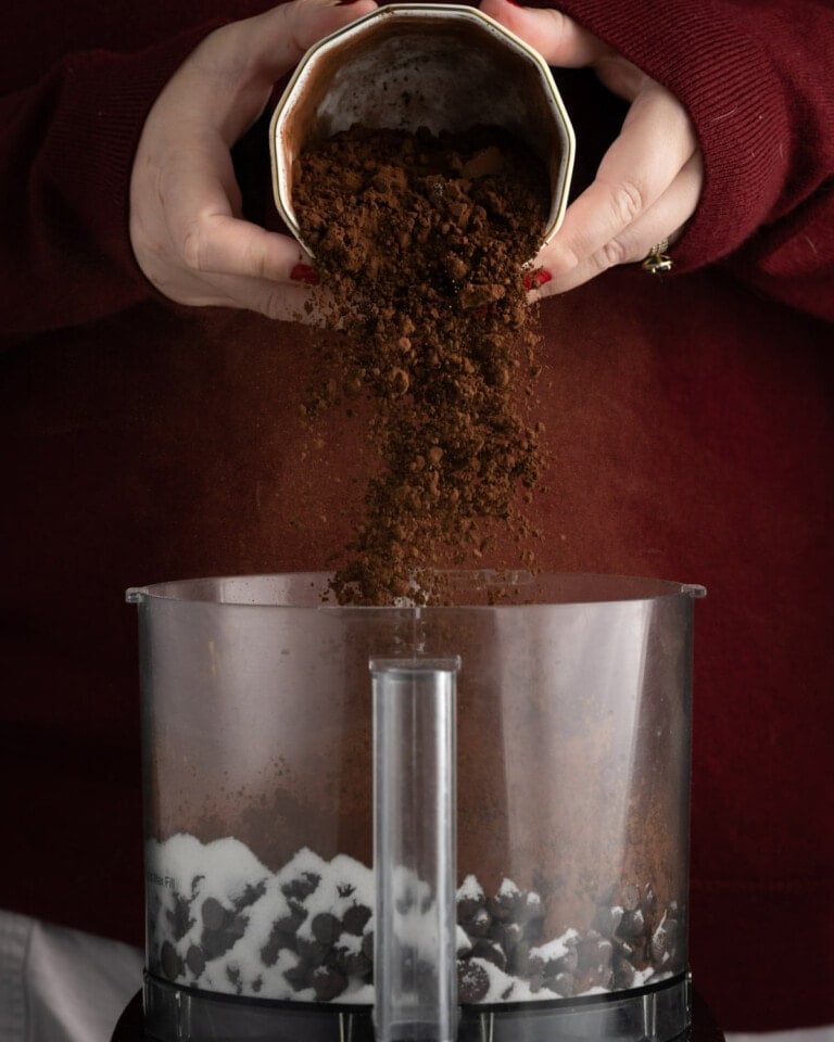 pouring cocoa powder into a food processor
