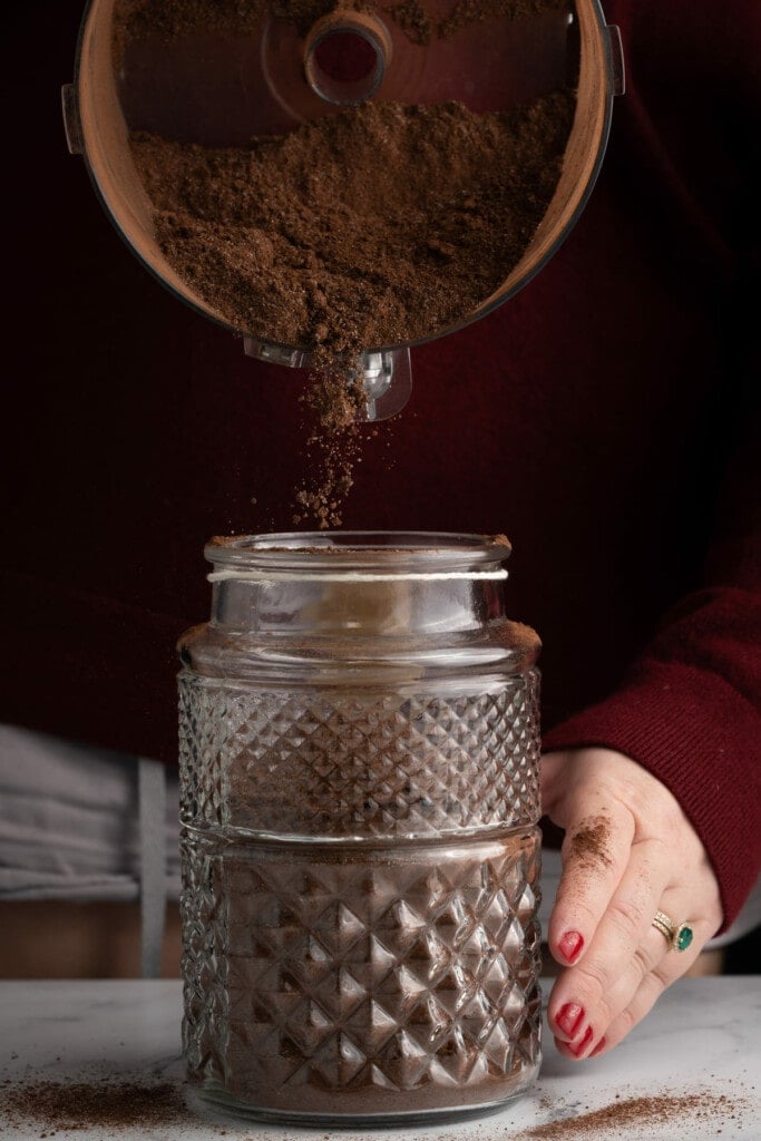 Transferring homemade hot chocolate mix to a glass jar for storage