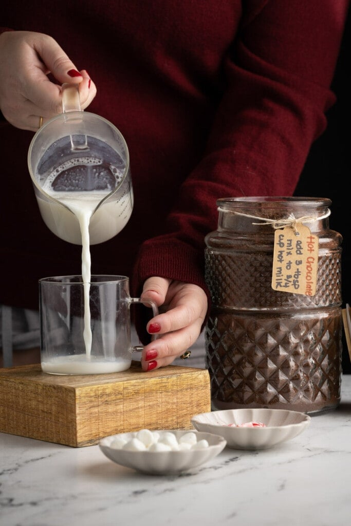 Pouring hot milk into a mug to make hot chocolate
