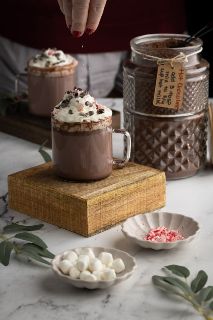 Garnishing hot chocolate with crushed peppermint candy cane