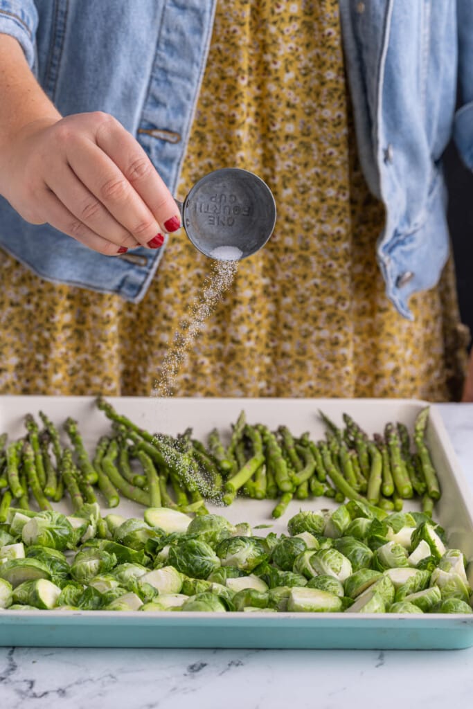 Seasoning asparagus and brussels sprouts with salt