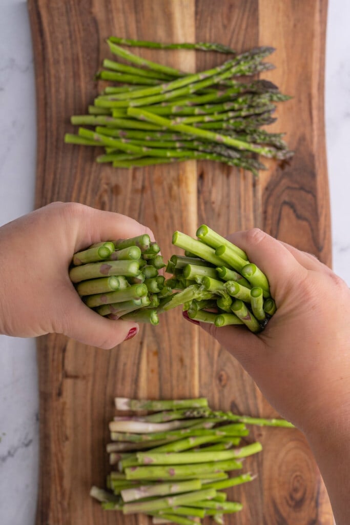 Snapping asparagus in half to break off woody ends