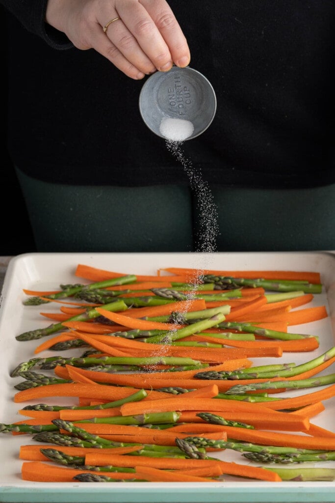 Adding salt to carrots and asparagus to roast