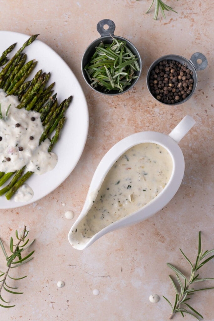 Shallot Cream Sauce in a gravy boat next to sauce-coated asparagus
