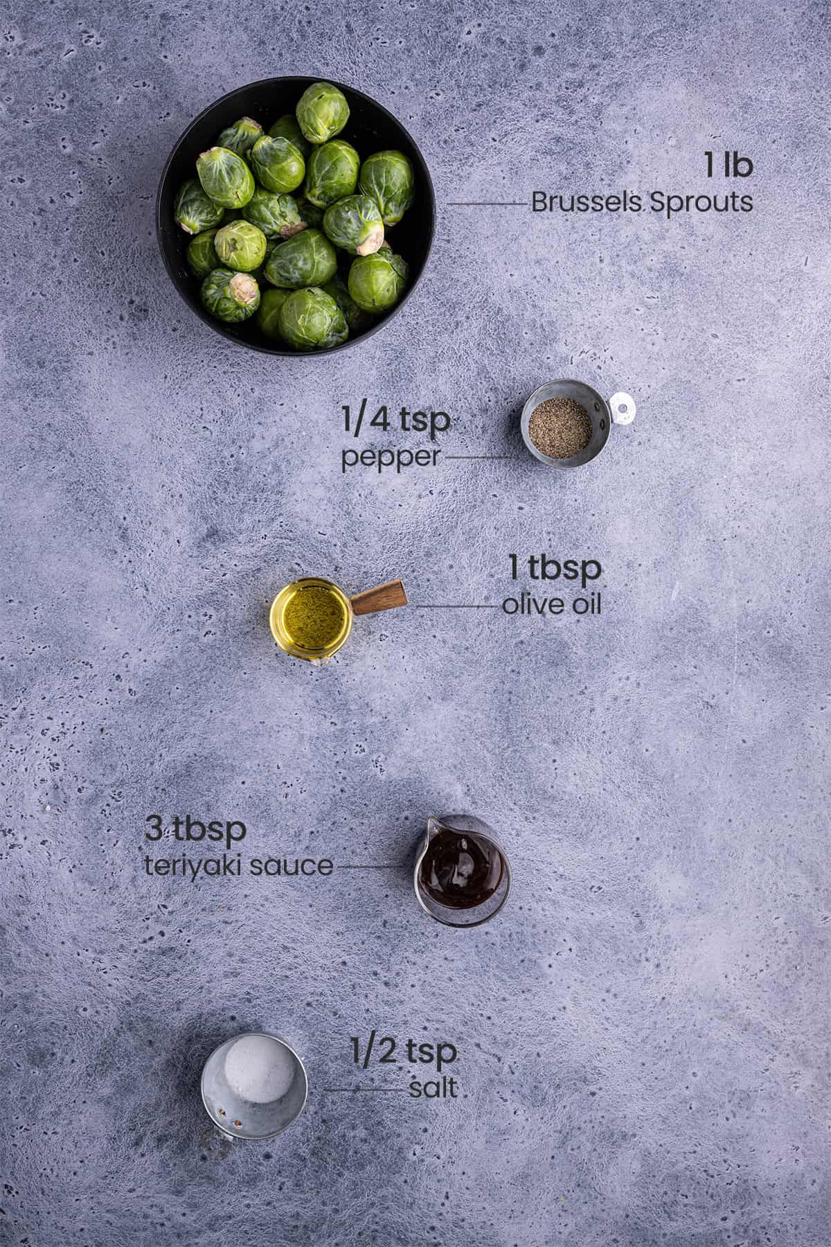 overhead view of ingredients for teriyaki brussels spouts - brussels sprouts, pepper, olive oil, salt, teriyaki sauce