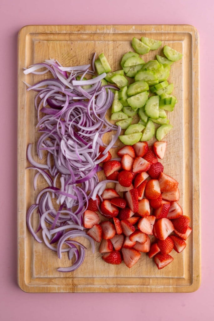 Sliced red onion, chopped cucumber, and sliced strawberries