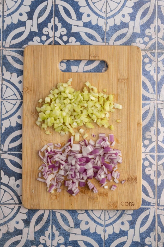 Diced celery and red onion on a chopping board