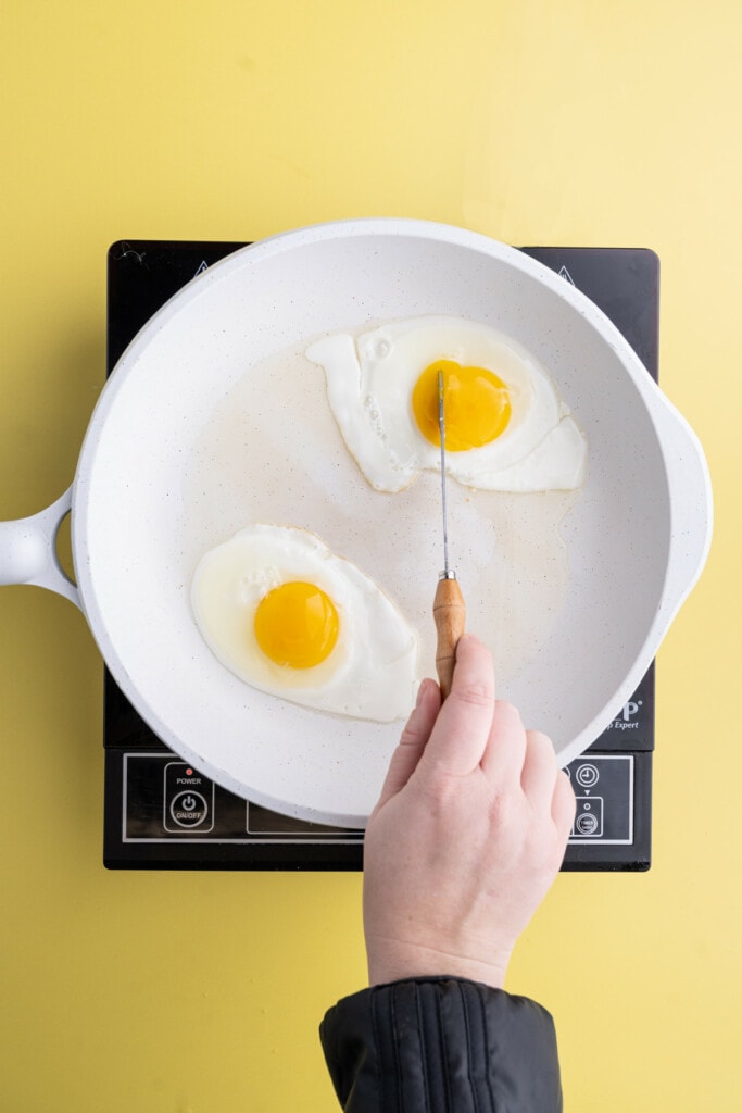 Piercing egg yolk with a knife to break it