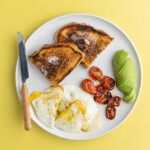 Over Hard Eggs served with toast and avocado and roasted tomatoes