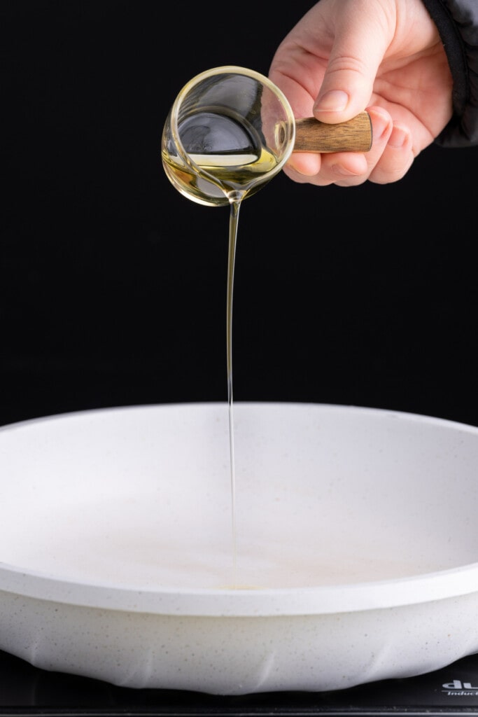 Adding olive oil to a pan to get hot before cracking eggs in it