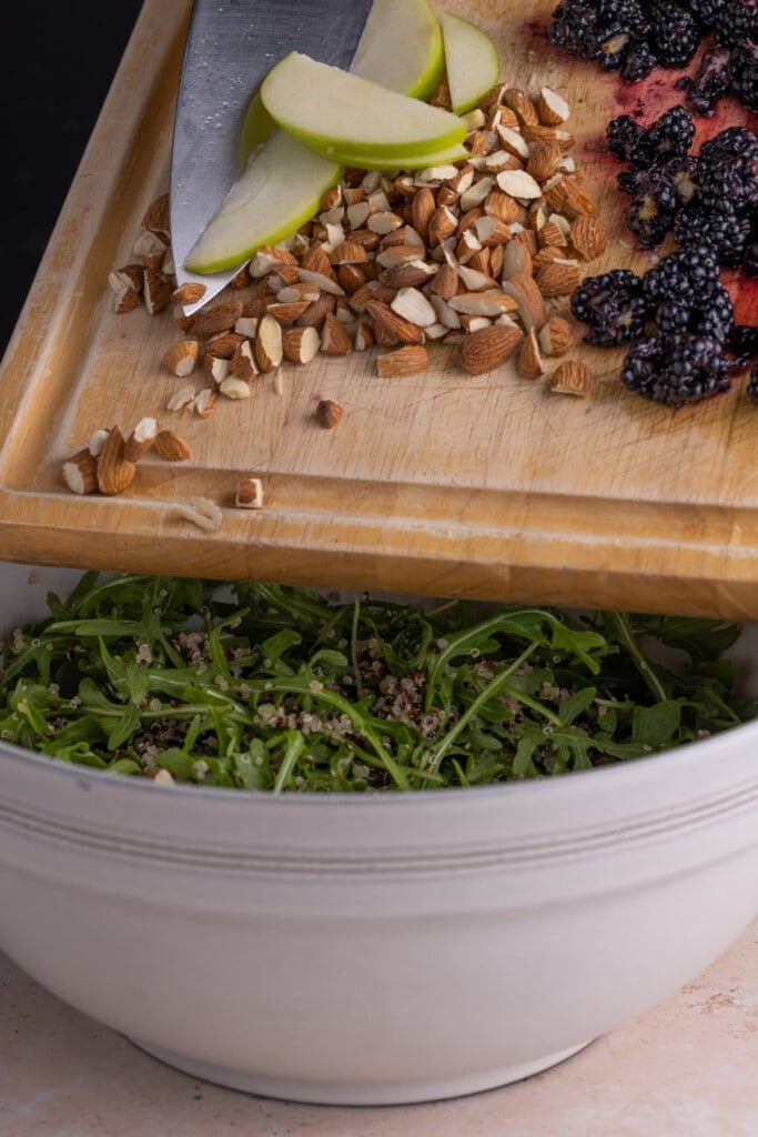 Adding all ingredients to Quinoa Arugula Salad