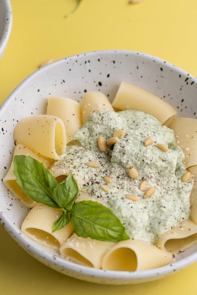 Bowl of Ricotta Pesto Pasta garnished with basil