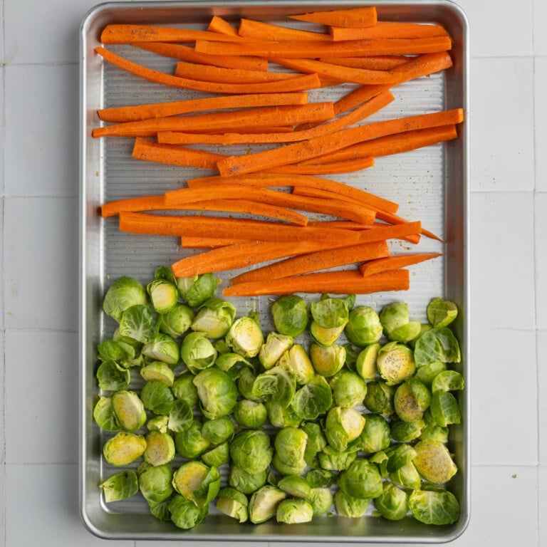 Sheet pan with carrots and brussels sprouts ready to roast