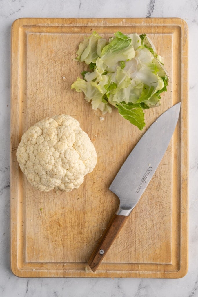 Cutting greens off of cauliflower.