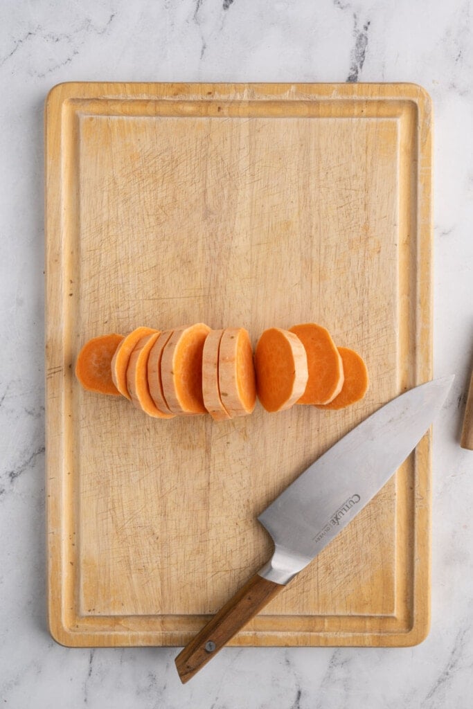 Slicing sweet potatoes into one-inch-thick pieces.