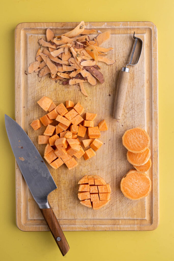 Chopping sliced sweet potato into cubes to roast quickly