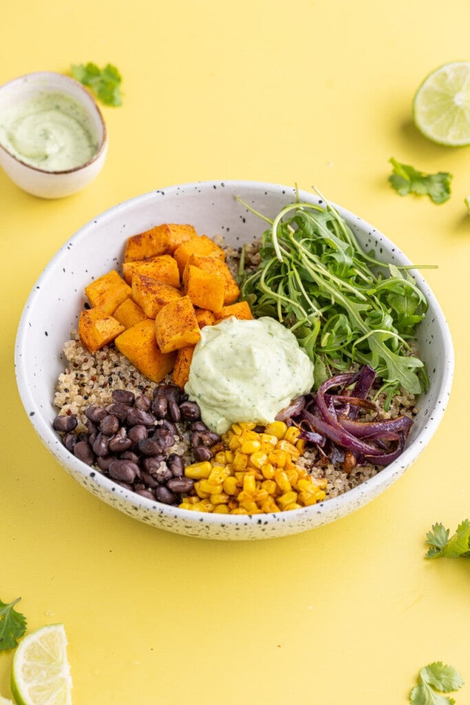 Sweet Potato Quinoa Bowl with fresh greens and a dollop of avocado crema