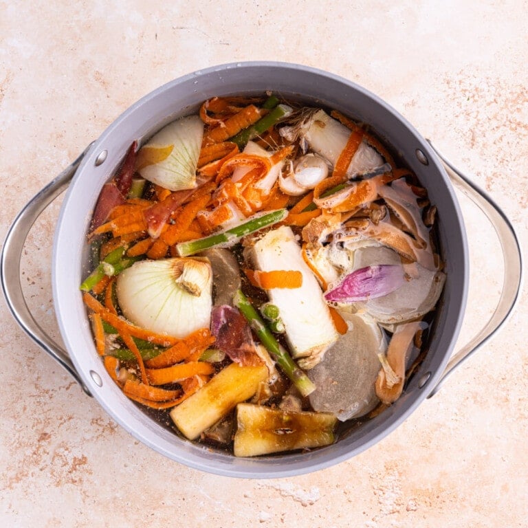 Veggie scraps submerged in water in a large pot