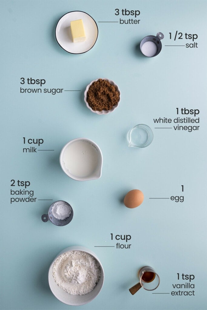 All ingredients for Brown Sugar Pancakes including butter, salt, dark brown sugar, white distilled vinegar, milk, egg, baking powder, vanilla extract, and all-purpose flour