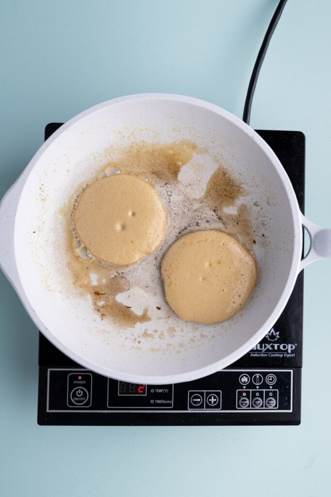 Frying two pancakes in a pan over medium heat