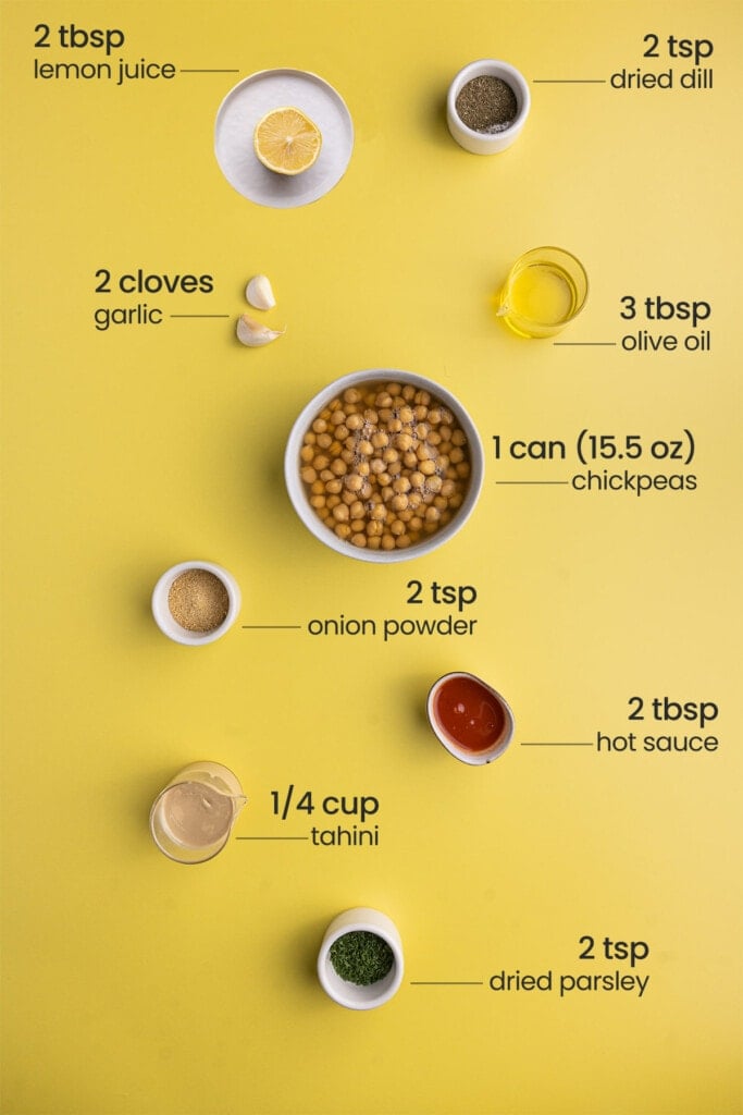 All Buffalo Ranch Hummus ingredients including lemon, dill, olive oil, garlic, canned chickpeas, onion powder, hot sauce, tahini, and dried parsley