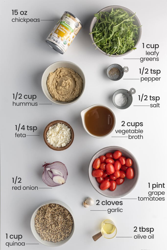 Ingredients for Mediterranean Quinoa Bowl including chickpeas, leafy greens, hummus, pepper, salt, vegetable broth, feta, grape tomatoes, red onion, garlic, quinoa, and olive oil