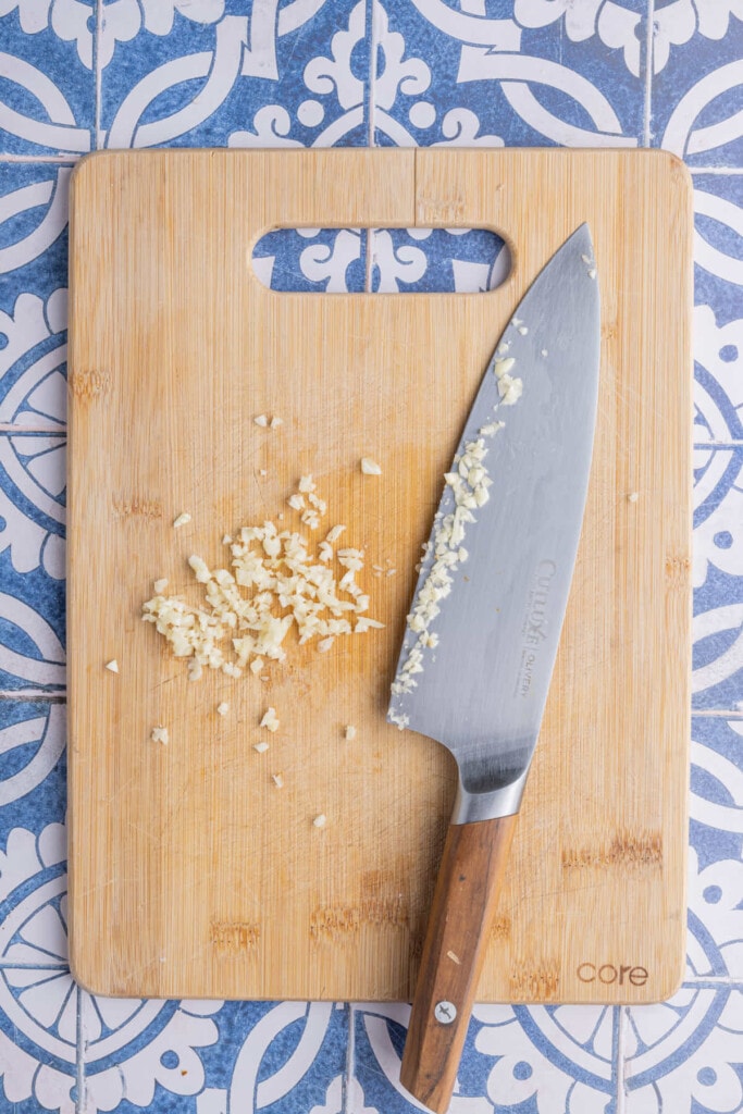 Using a sharp knife to mince fresh garlic