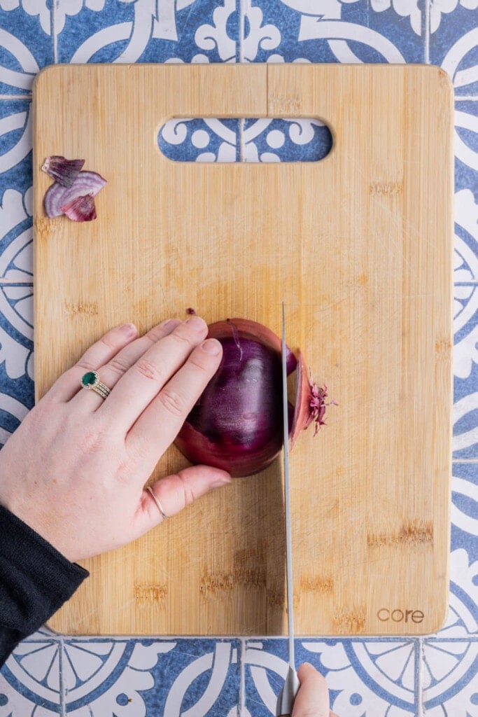 Slicing a red onion by first chopping off the ends