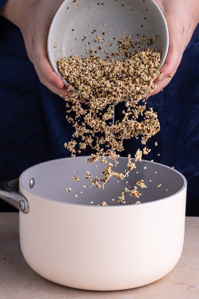 Cooking quinoa in vegetable broth to make a flavorful base for breakfast bowl