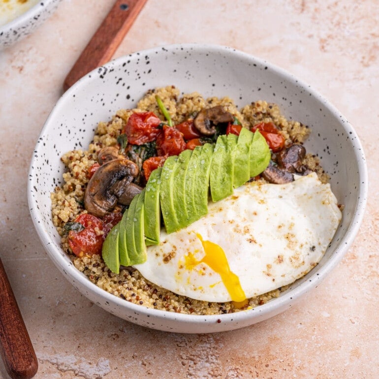 Savory Quinoa Breakfast Bowl with runny yolk on egg