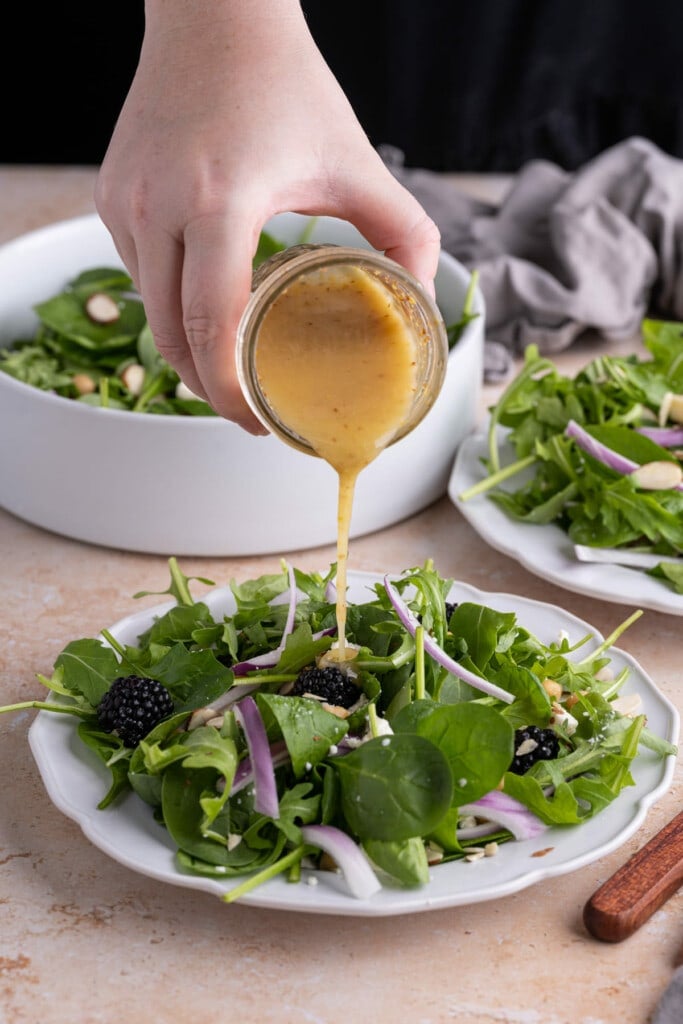 Adding Honey Dijon Vinaigrette to salad just before serving