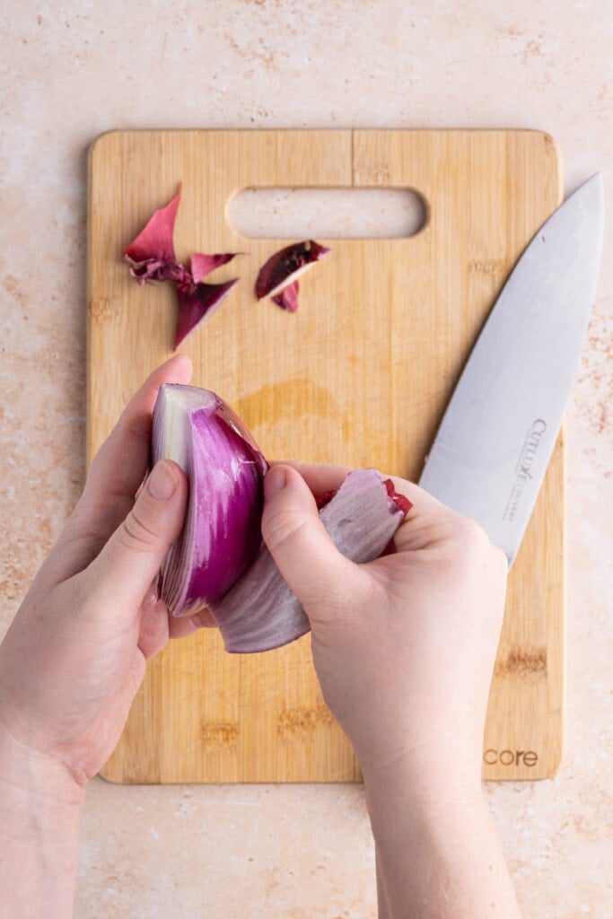 Peeling outer layer off of red onion