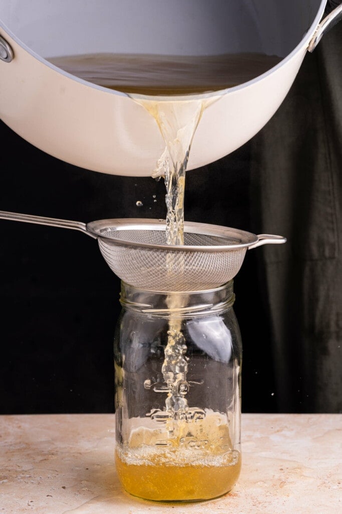 Pouring vegetable broth through a sieve