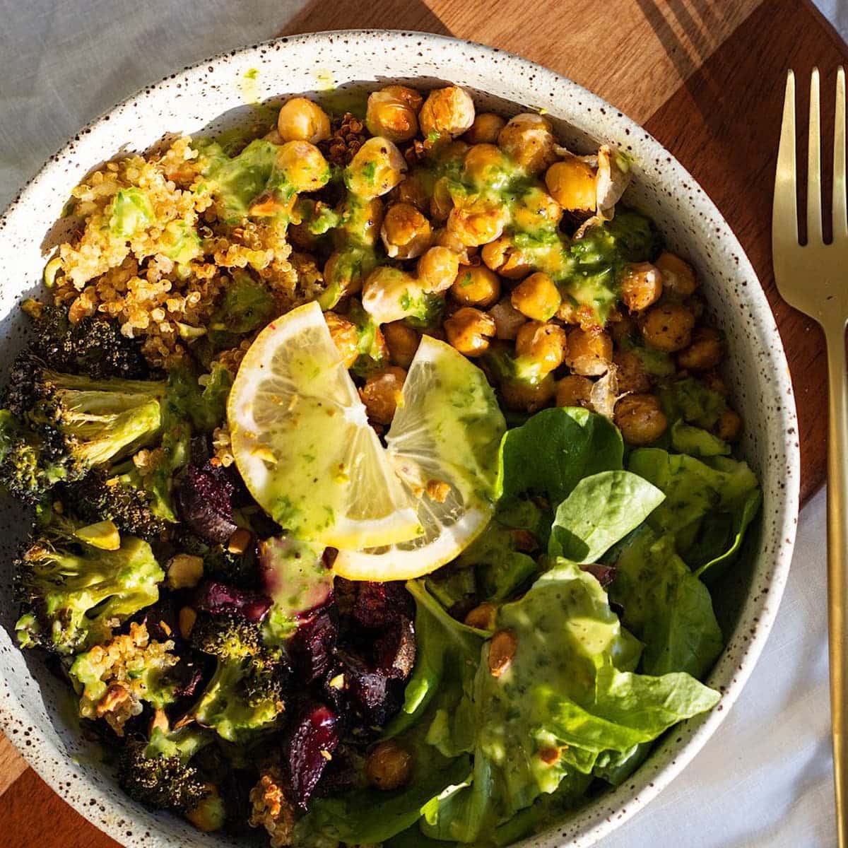 Close up of a Winter Crispy Chickpea Quinoa Nourish Bowl on a table with a fork