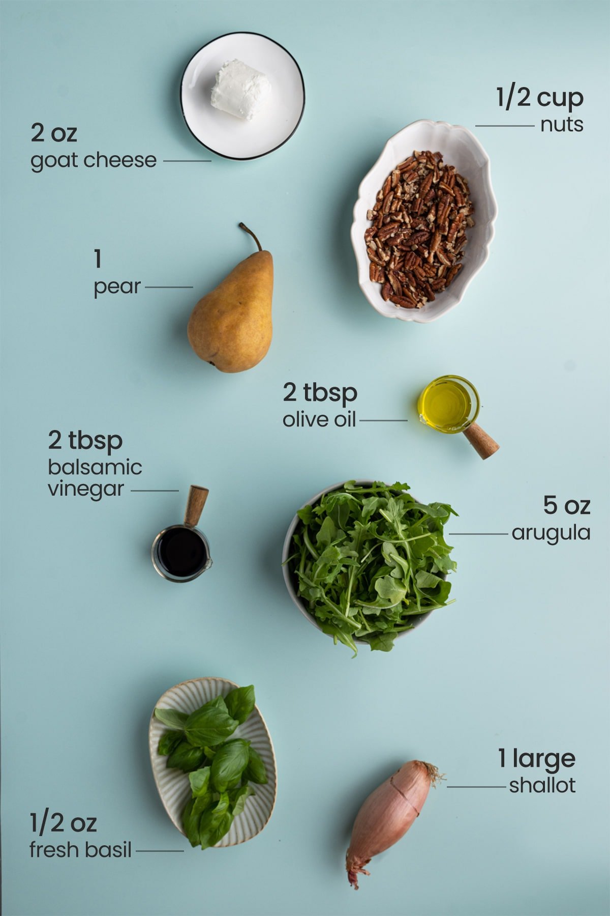 ingredients for arugula pear salad - goat cheese, nuts, pear, olive oil, balsamic vinegar, arugula, basil, shallot