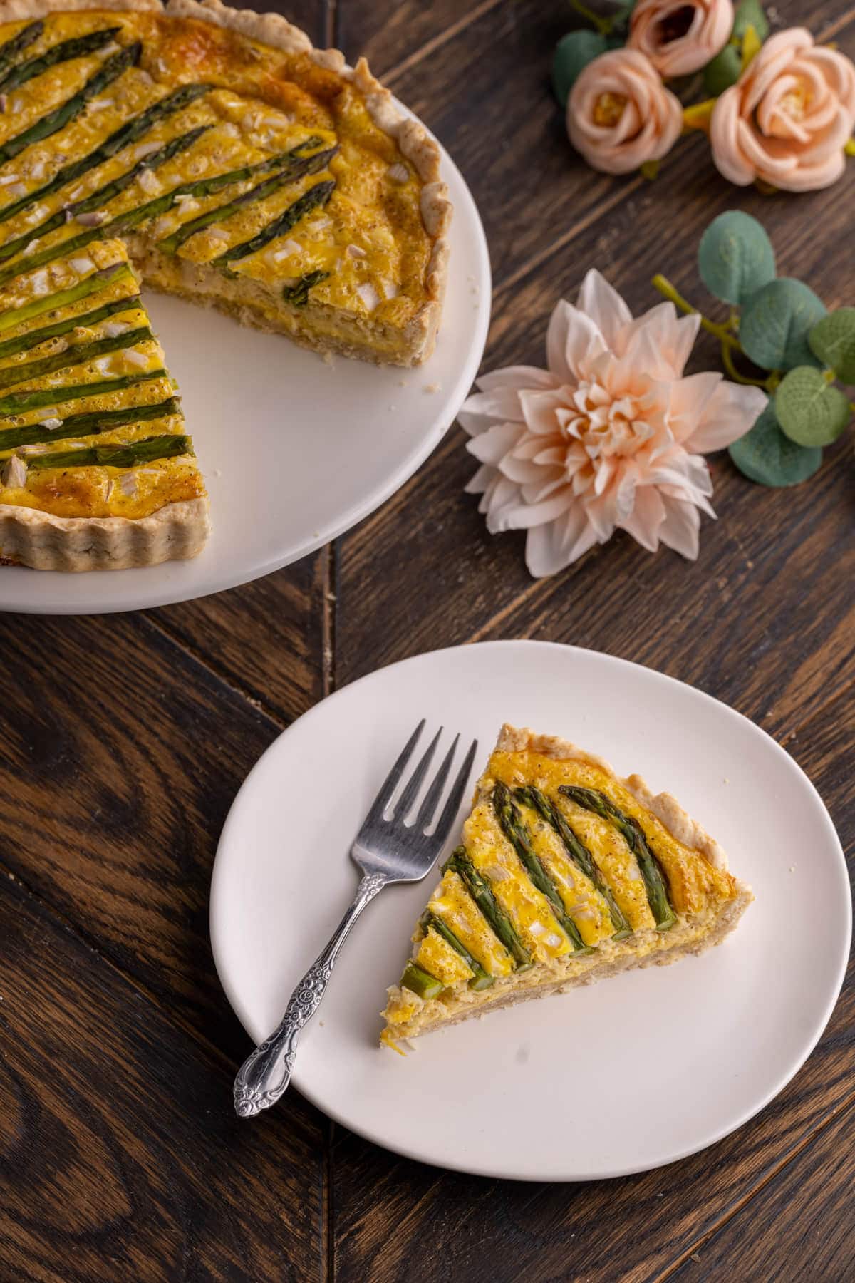 Asparagus Quiche on a plate with full quiche in the background