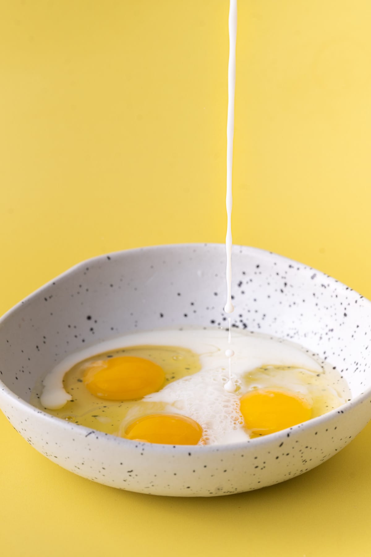 Adding milk to eggs to make egg wash