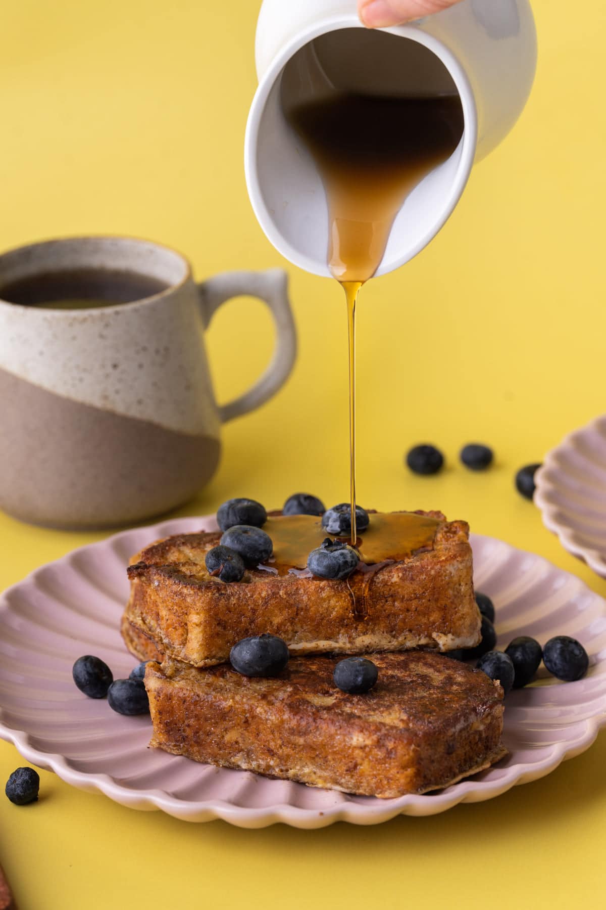 Drizzling syrup over stack of Banana Bread French Toast