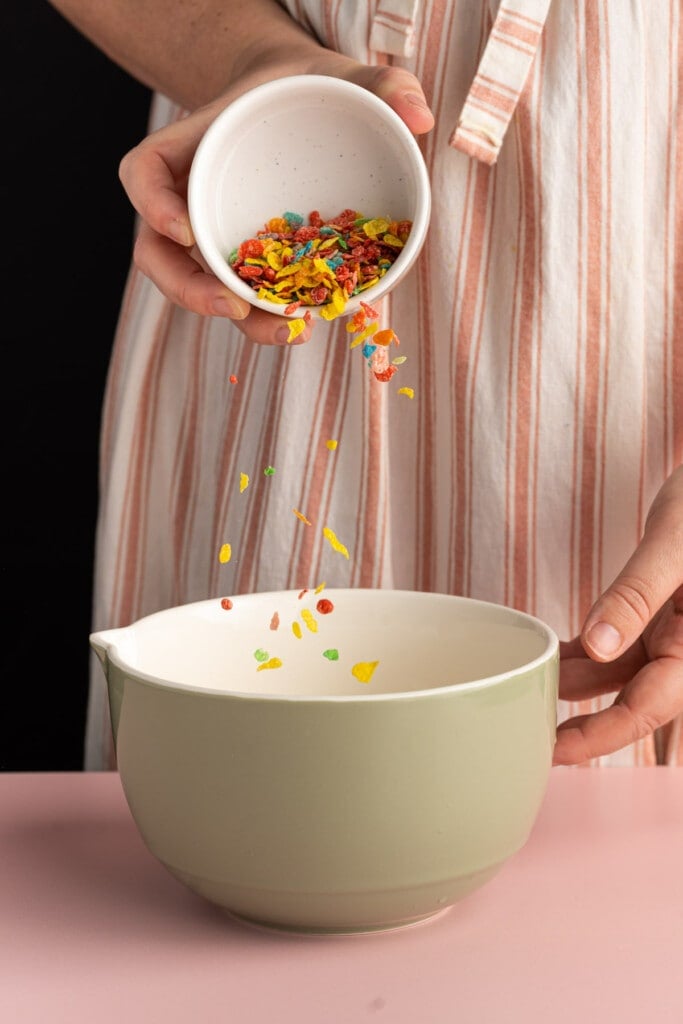 Adding Fruity Pebbles to bowl with heavy cream to soak