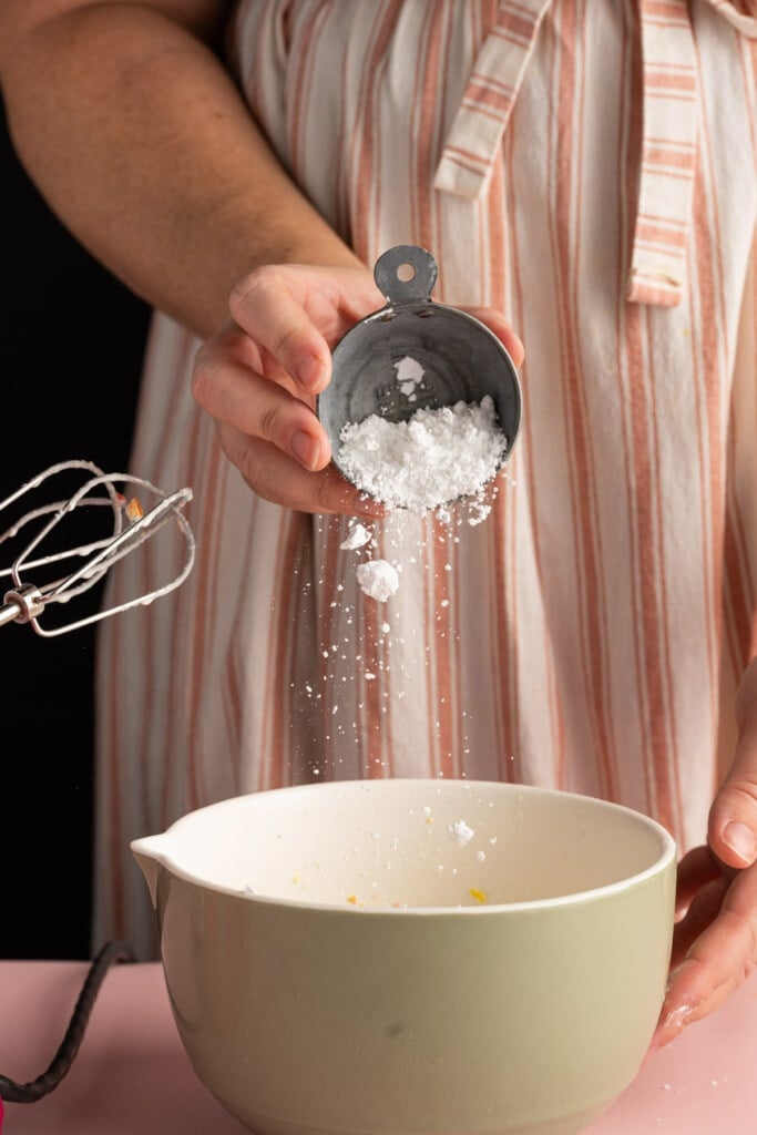 Adding powdered sugar to cream and fruity pebbles to make Cereal Milk Whipped Cream