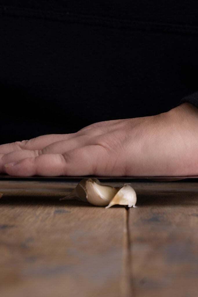 Crushing garlic to peel it for the food processor