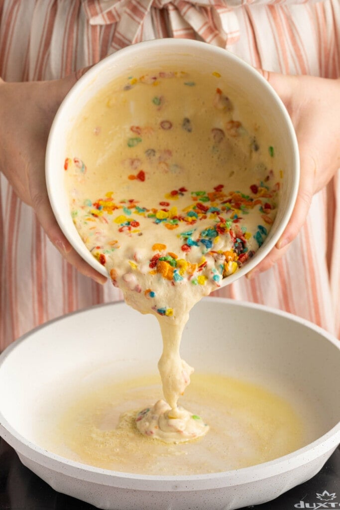 Adding pancakes batter to hot pan with butter