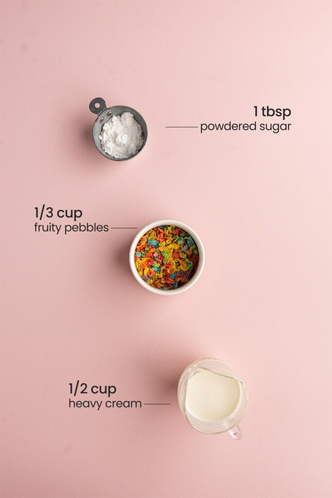 Ingredients for cereal milk whipped cream including heavy whipping cream, Fruity Pebbles, and powdered sugar