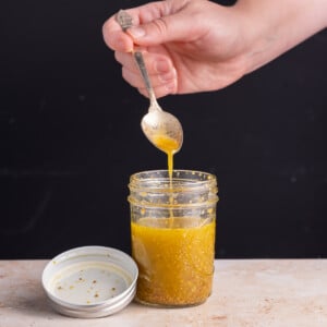 Maple Dijon Vinaigrette running off a spoon into a jar