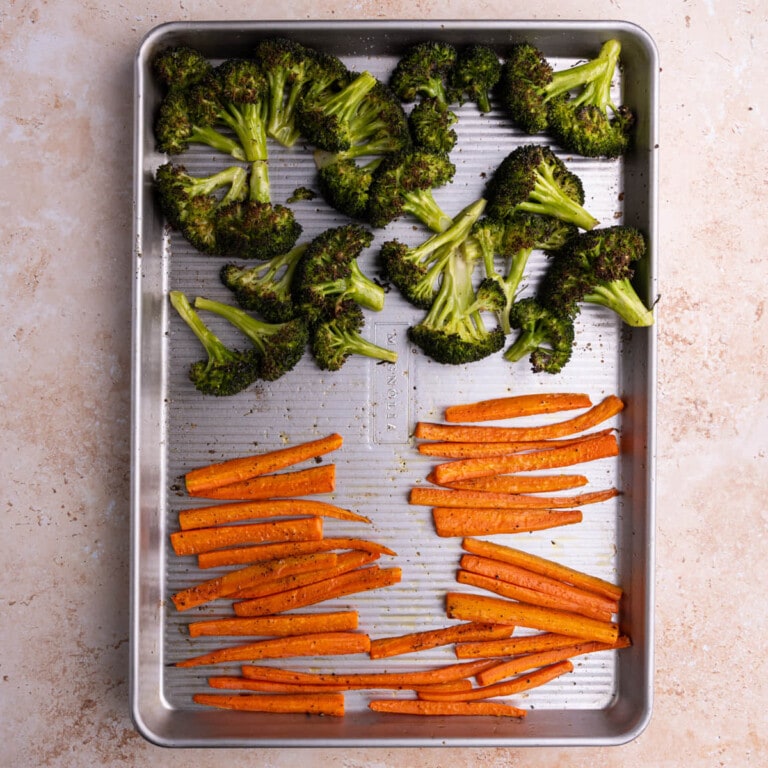 Roasted broccoli and carrots on a baking sheet