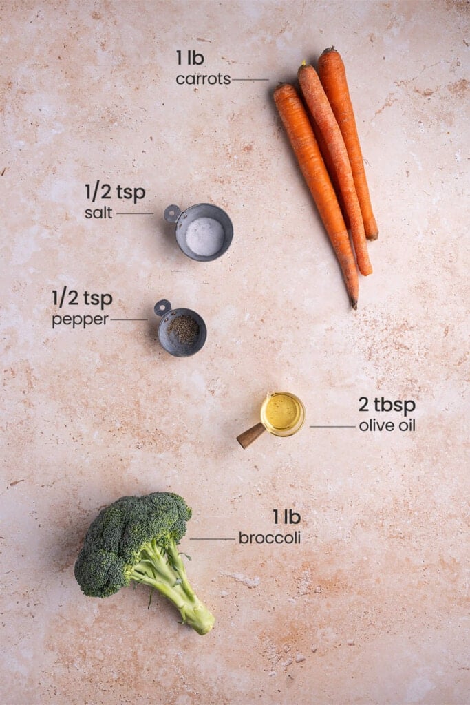 All ingredients for Roasted Broccoli and Carrots including whole carrots, salt, pepper, broccoli and olive oil